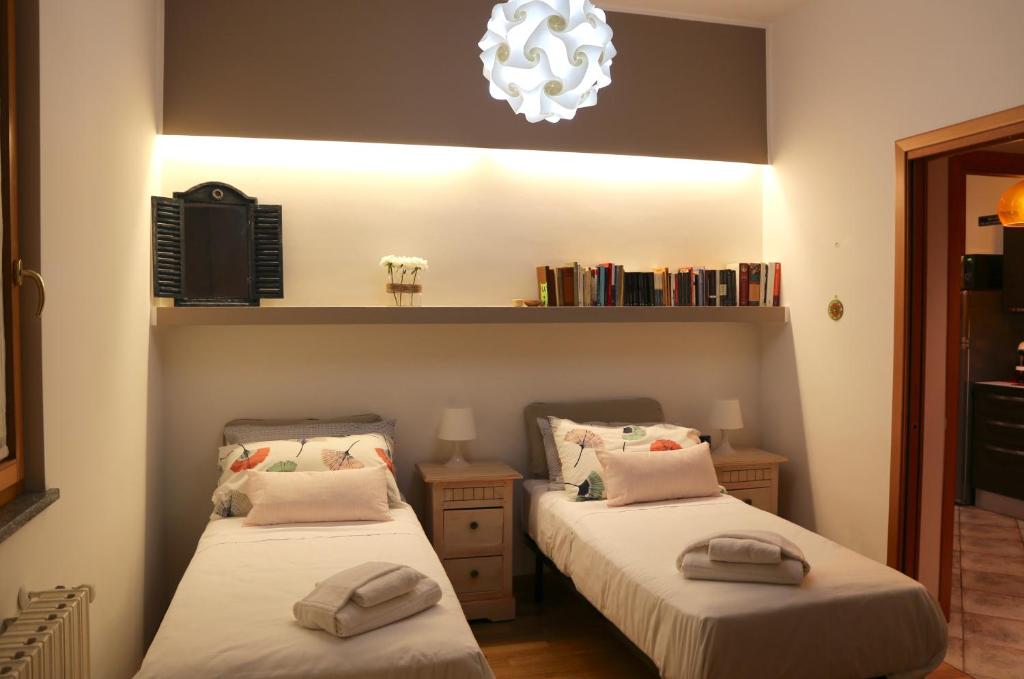 um quarto com 2 camas e um lustre em Bnbook-Tommaso Grossi Rho Fiera em Rho