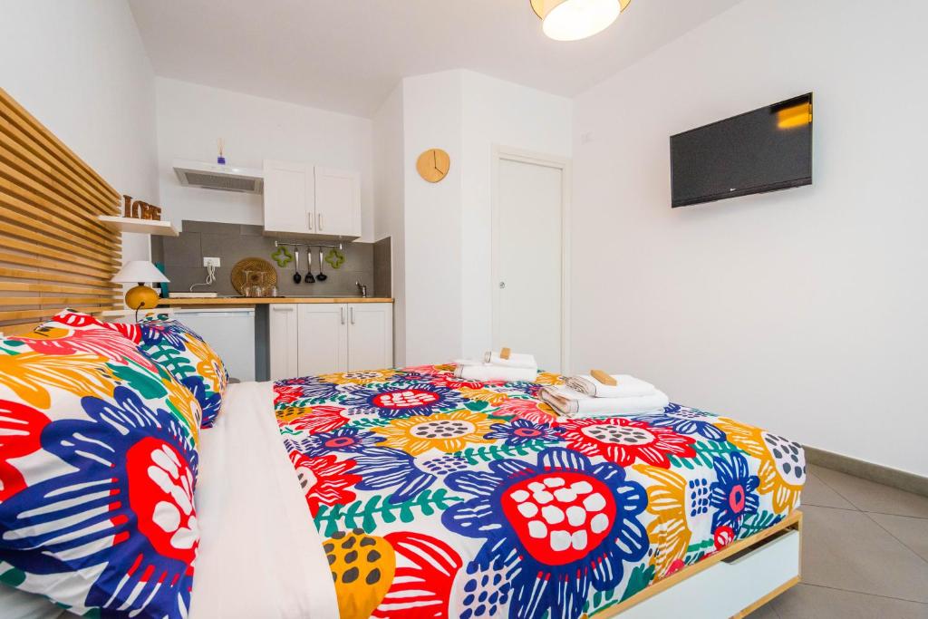 een slaapkamer met een bed met een kleurrijke deken bij B&B Lo&G in Lascari