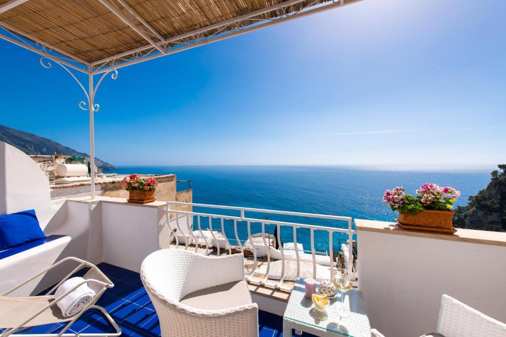 Un balcón con sillas y vistas al océano. en Casa Guadagno en Positano
