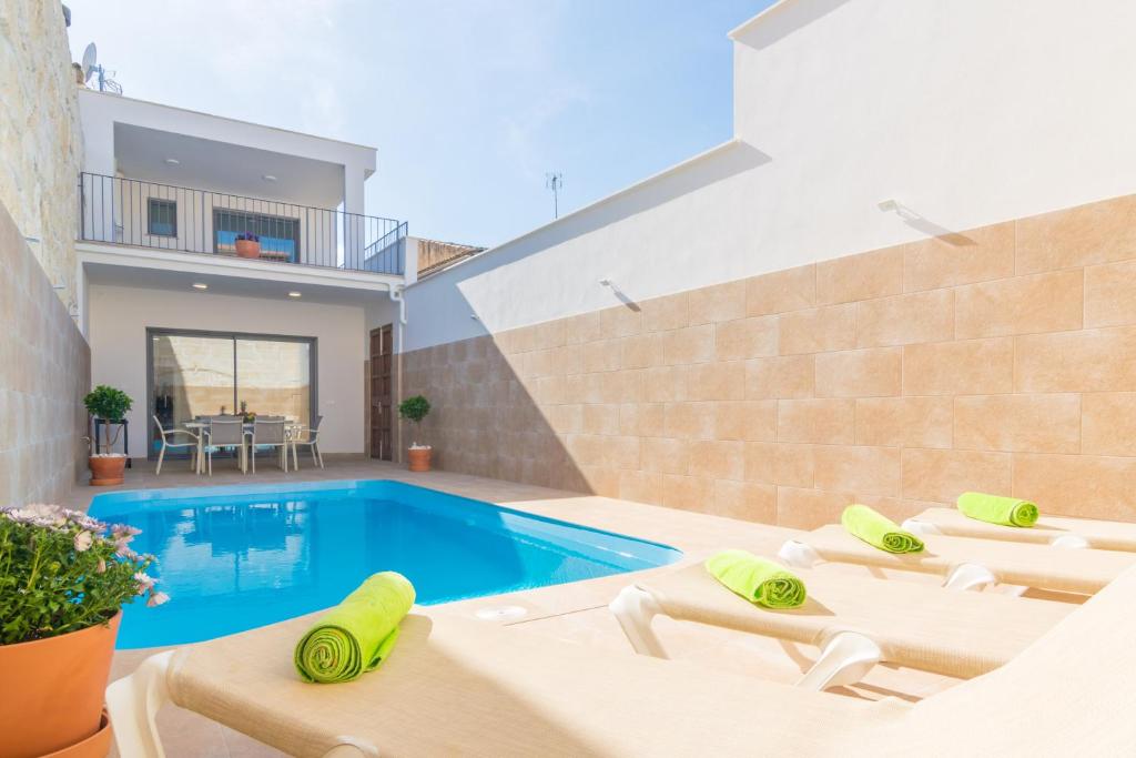 a villa with a swimming pool and lounge chairs at Can Serra in Sa Pobla