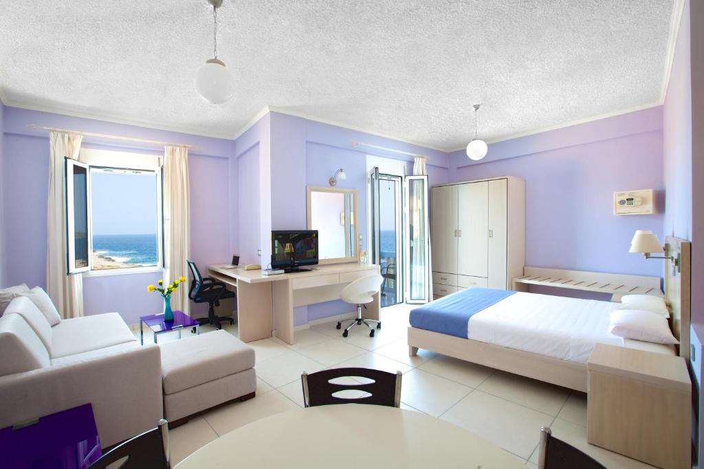 1 dormitorio con paredes de color púrpura, 1 cama y escritorio en Giorgi's Blue Apartments, en Kalathas