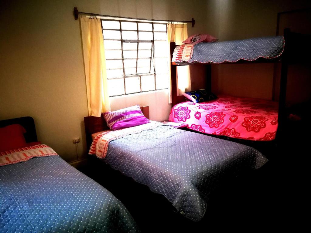1 dormitorio con 2 camas y ventana en Tinki Hostel, en Cusco
