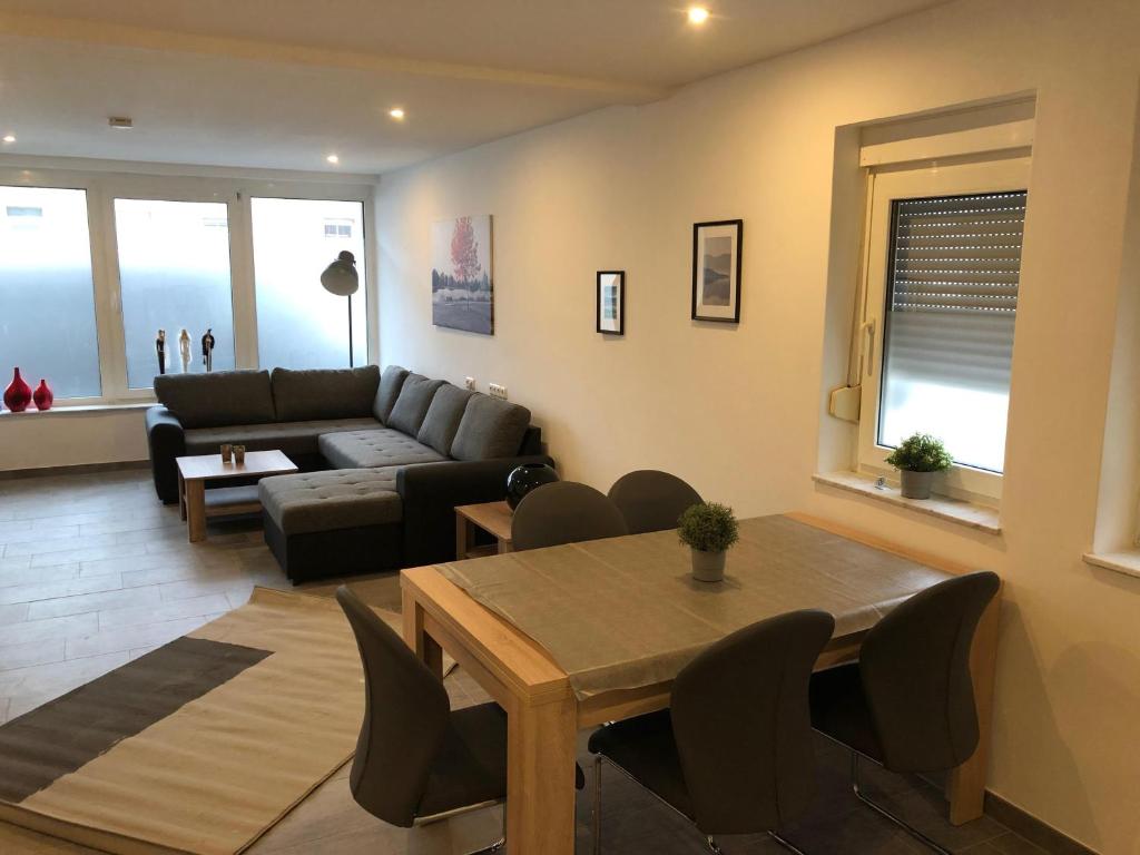 a living room with a couch and a table and chairs at City Apartment Dietze in Übach-Palenberg