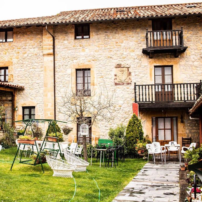 a building with a yard with chairs and tables at Posada de Bielva in Bielva