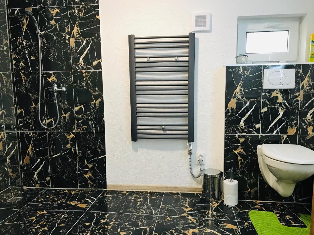 a black and gold bathroom with a toilet in it at Chata pod Lysou Horou in Ostravice
