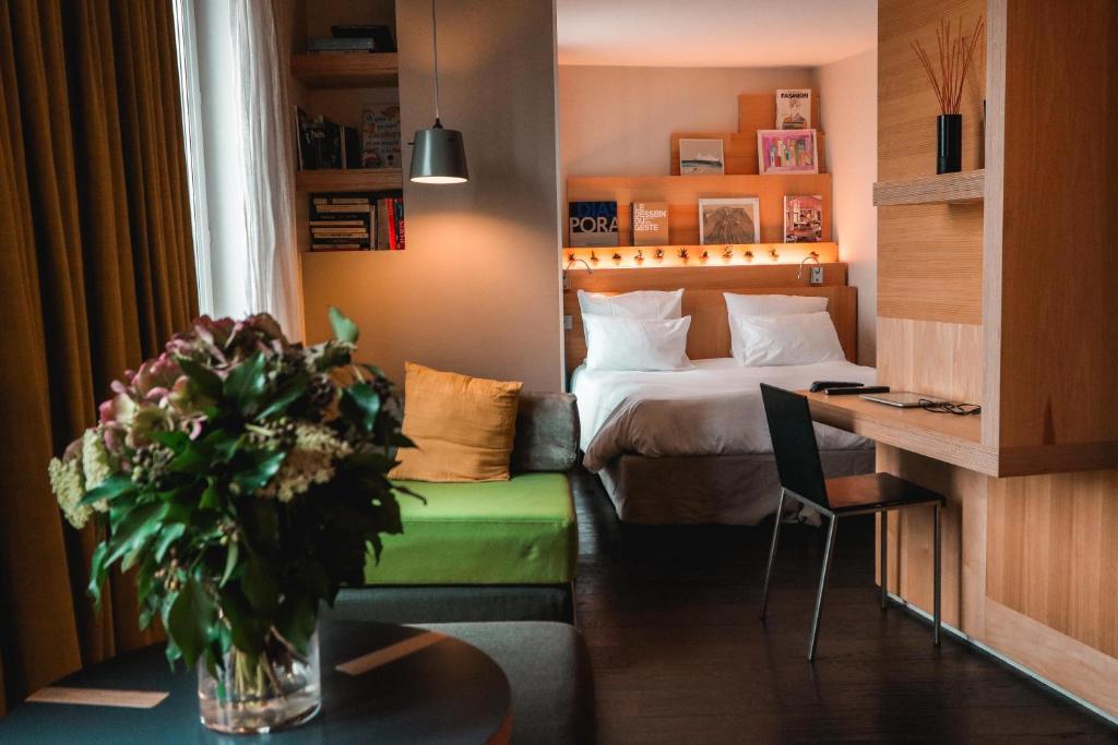 a hotel room with a bed and a vase of flowers at Le Citizen Hotel in Paris
