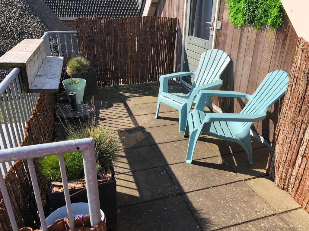 zwei blaue Stühle auf einer Terrasse in der Unterkunft Casa Sophie in Giethoorn