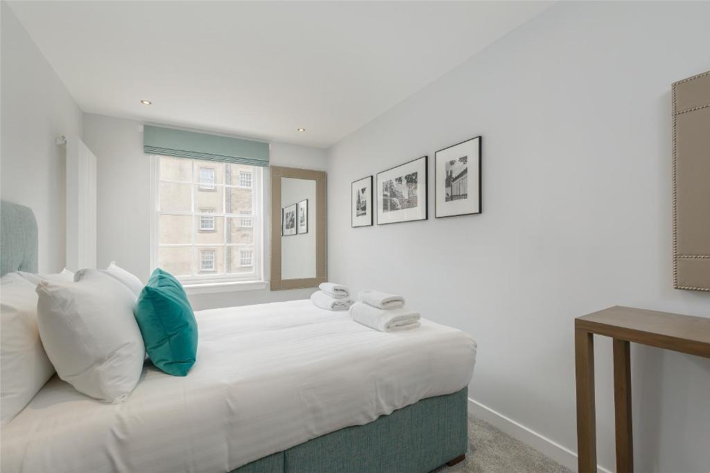 a bedroom with a large white bed with blue pillows at Destiny Scotland - Royal Mile Residence in Edinburgh
