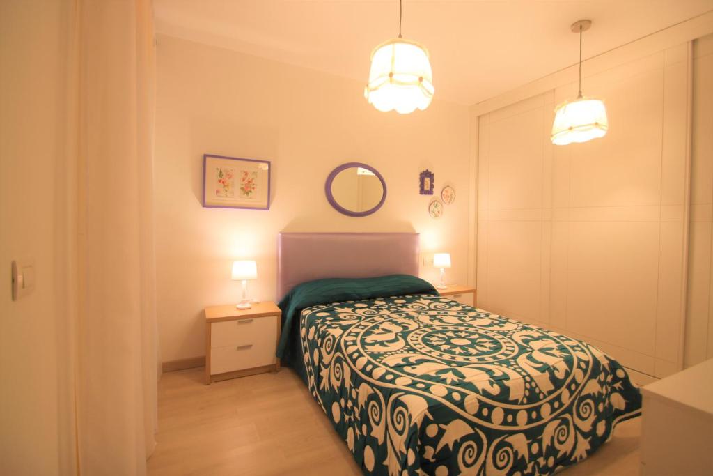 - une petite chambre avec un lit et deux lumières dans l'établissement Apartamento CasaTuris cerca del aeropuerto de El Altet AT101, à Alicante