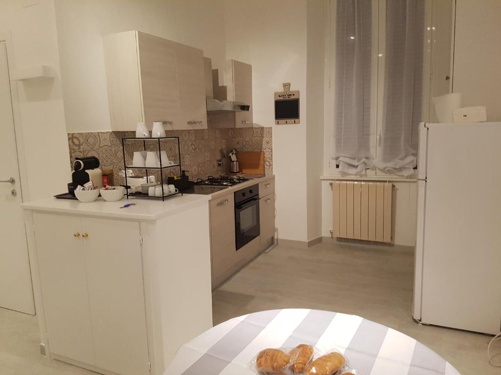 una cucina con armadietti bianchi e frigorifero bianco di Your home near to the Vatican a Roma