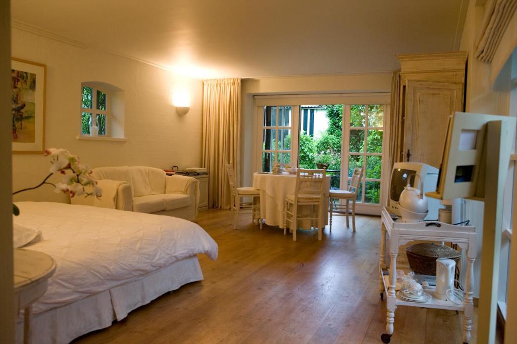 ein Schlafzimmer mit einem Bett und ein Wohnzimmer in der Unterkunft Veerhoeve in Sluis