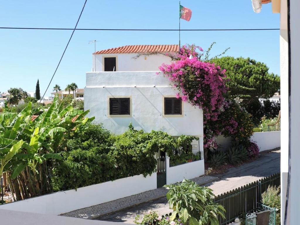 Una casa blanca con flores a un lado. en Casa Portuguesa, en Albufeira