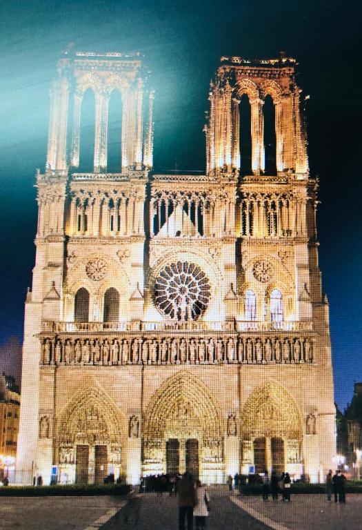 une grande cathédrale avec une tour d'horloge la nuit dans l'établissement SAINT PAUL 22, à Paris