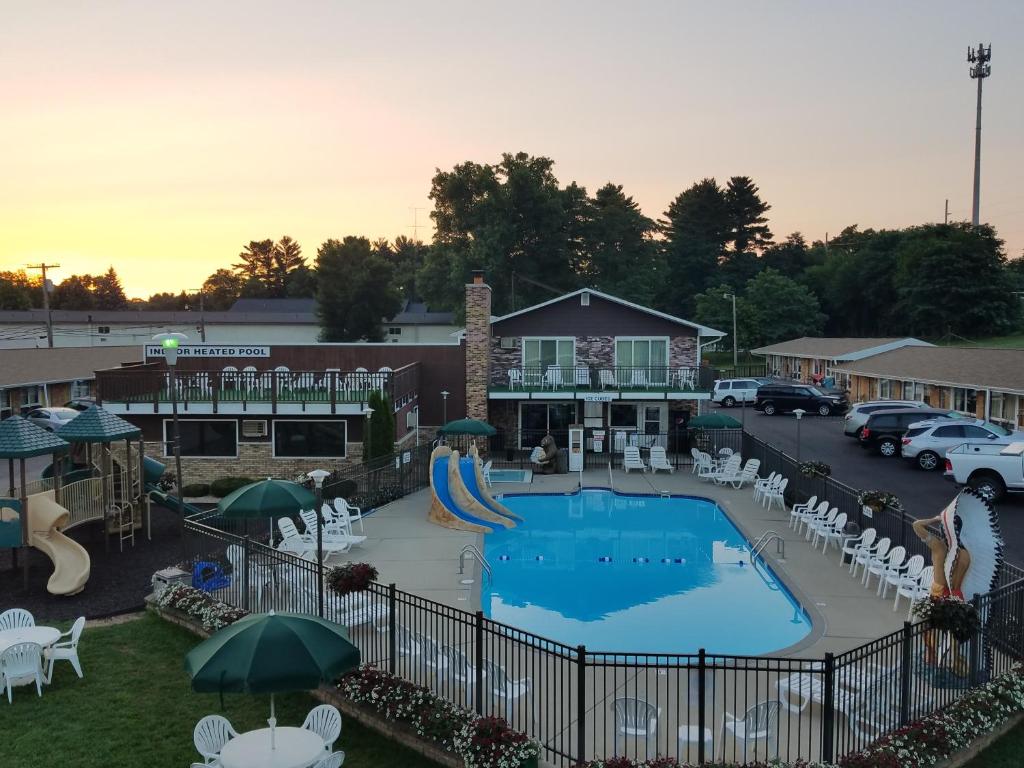 una piscina all'aperto con scivolo, sedie e sdraio di Black Hawk Motel & Suites a Wisconsin Dells