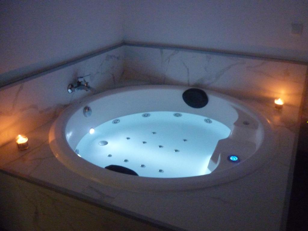 uma grande banheira com luzes num quarto em Apartamento La Gloria em Gibaja