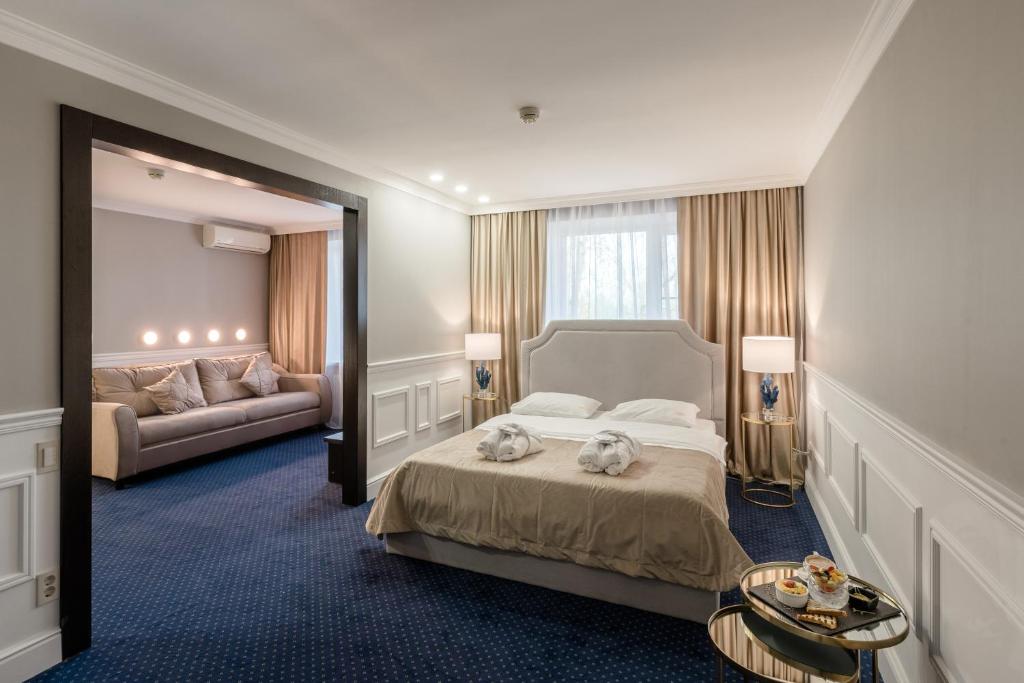 um quarto de hotel com uma cama e um espelho em Jardin Park Hotel em Rostov on Don