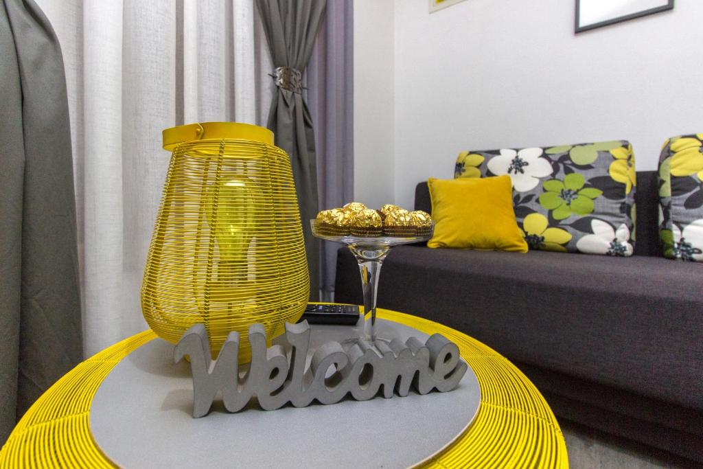 een woonkamer met een tafel met een gele lamp bij Apartments Slavica in Šibenik