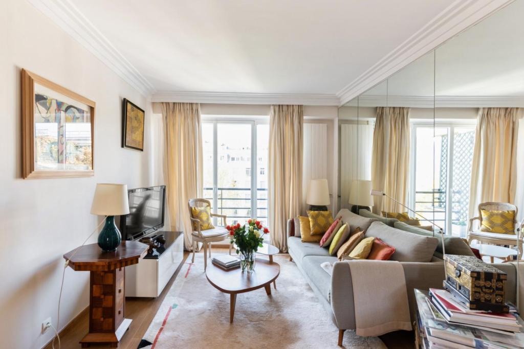 a living room with a couch and a tv at Bright and charming two-bedroom close to Eiffel Tower Paris in Paris