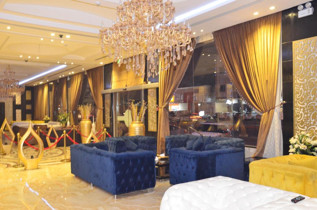 Zahrat Rozah By Quiet Rooms في الرياض: لوبي فيه كنب ازرق وثريا
