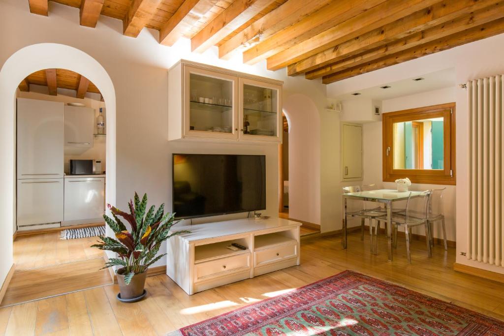 a living room with a flat screen tv and a table at Downtown Apartment Verona in Verona