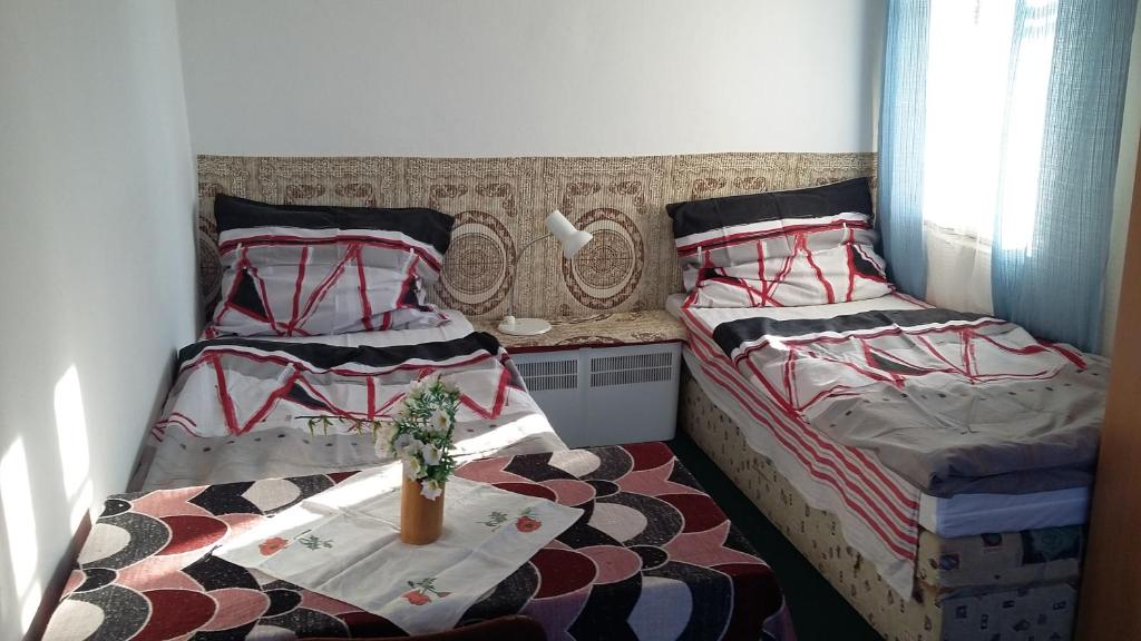 a bedroom with two beds and a table in it at EKO-penzion Hamry in Žiželice