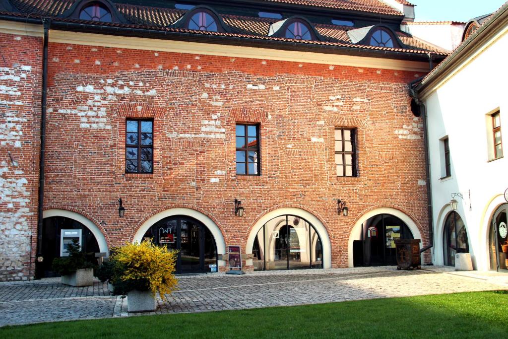 a red brick building with arches and windows at Dom Gości Opactwa Benedyktynów in Tyniec