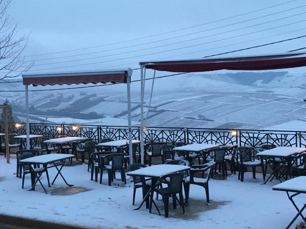 a group of tables and chairs covered in snow at Hotel du Rempart in Sancerre