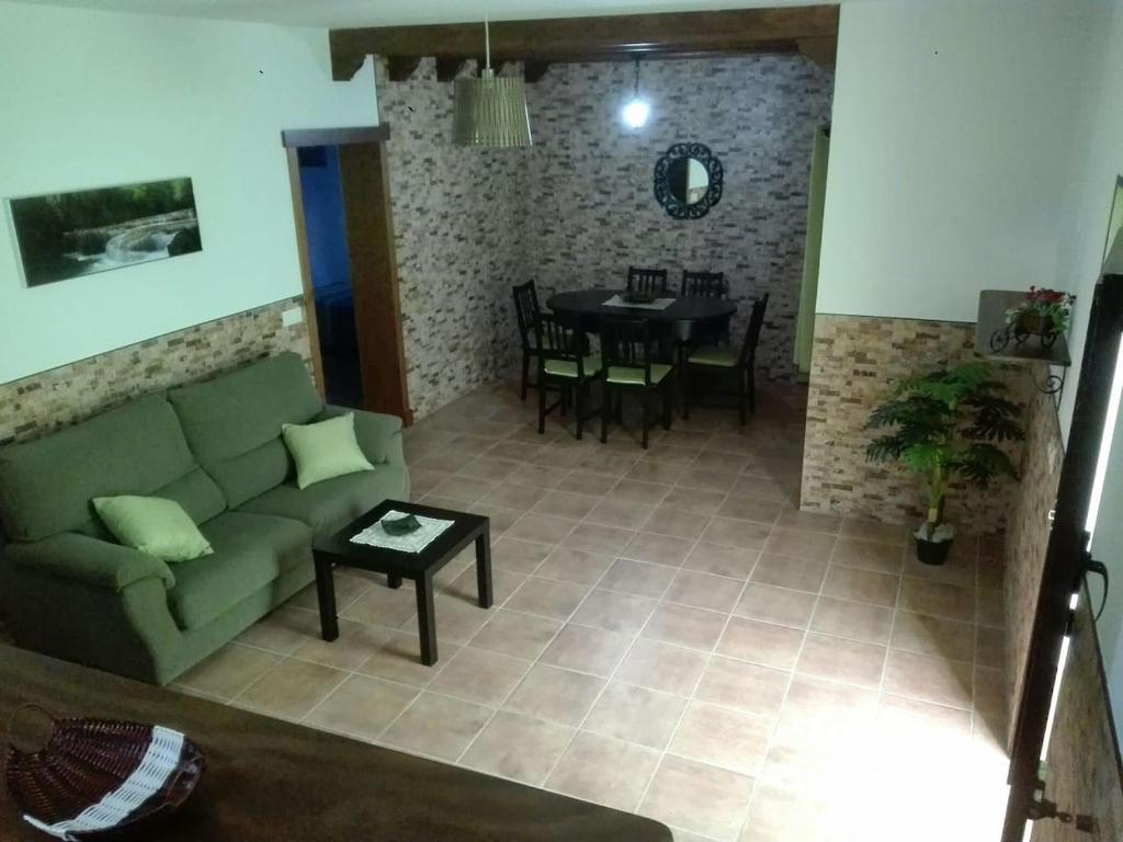 sala de estar con sofá verde y mesa en Casa 100m2, en Chiclana de la Frontera