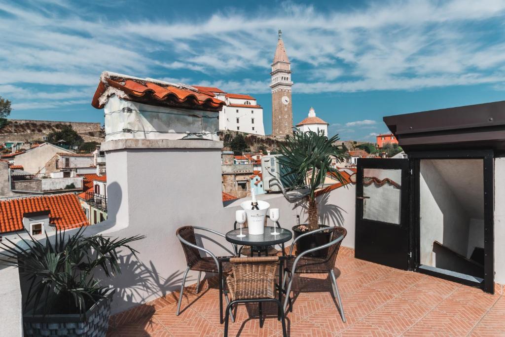 a balcony with a table and chairs and a clock tower at Apartma Remi in Piran