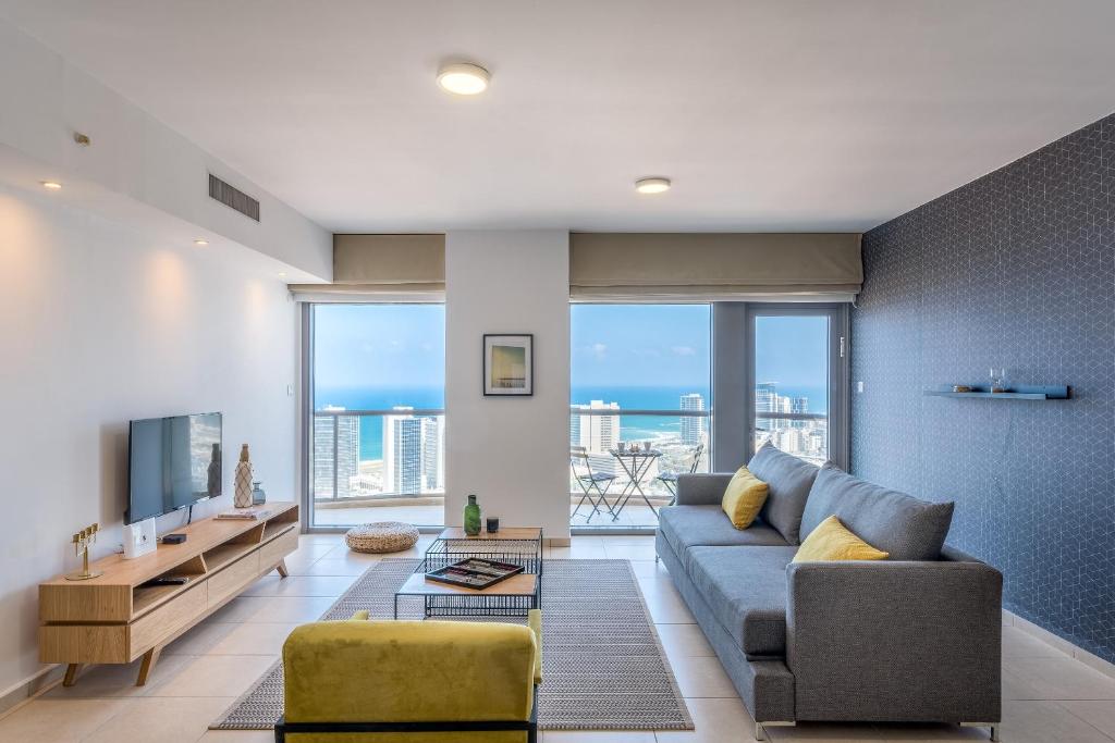 Cosy and sunny apartment in Nevet Tsedek with pool في تل أبيب: غرفة معيشة مع أريكة وتلفزيون