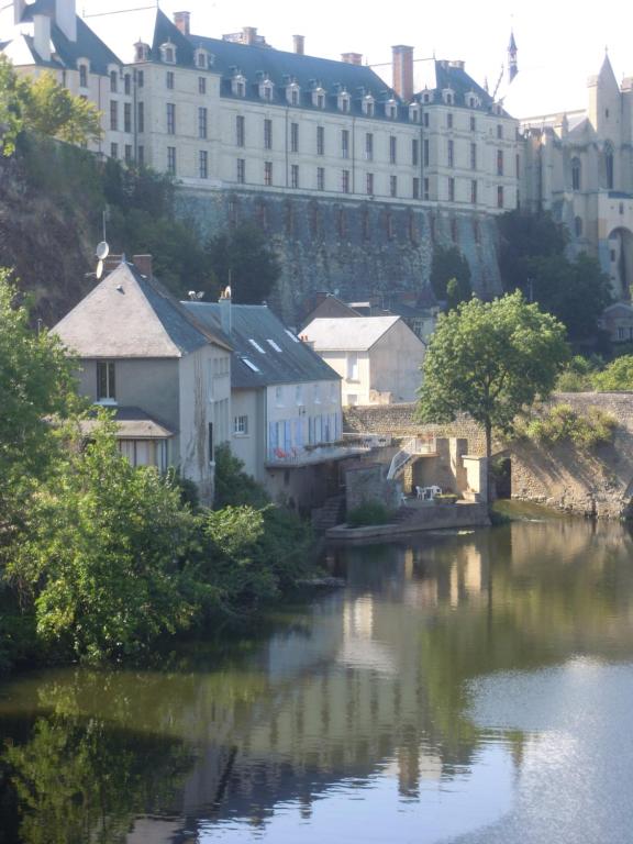 uma vista para um rio com edifícios ao fundo em MOULIN DE L'ABBESSE em Thouars