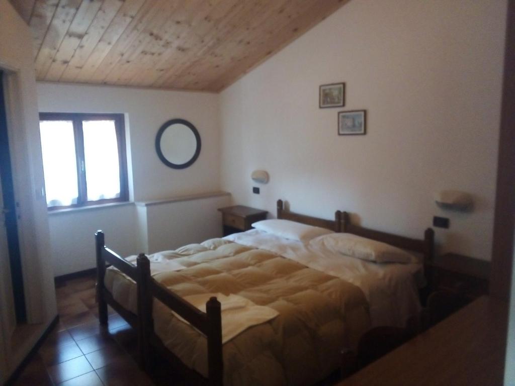 1 dormitorio con cama y ventana en La Foresta Albergo Ristorante Pizzeria, en Badia Prataglia