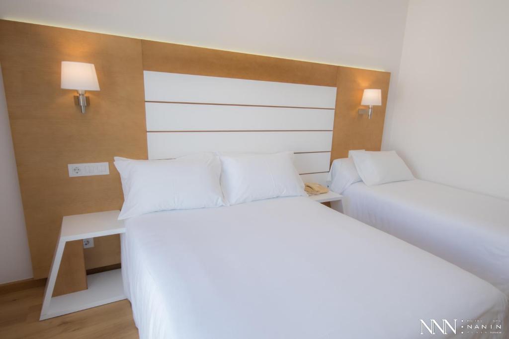 A bed or beds in a room at Hotel Spa Nanin Playa