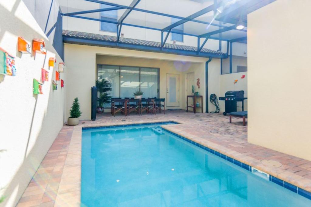 una piscina frente a una casa en Luxurious Vacation Townhome with Private Pool at Windsor at Westside WW8948, en Kissimmee