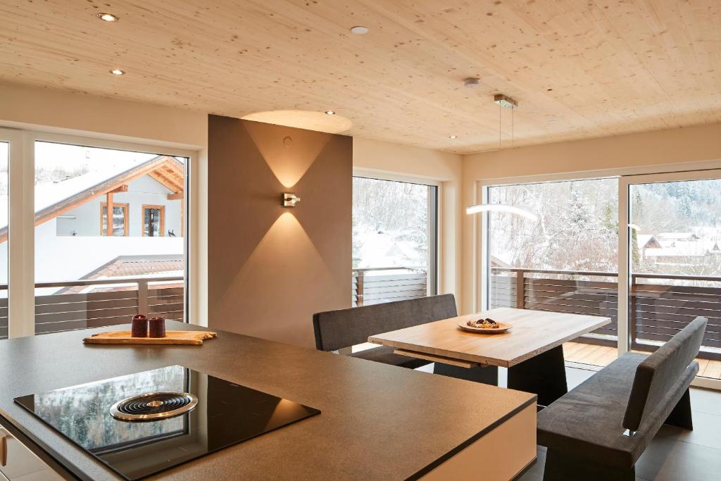a dining room with a table and chairs and windows at Apart Sailer in Ried im Oberinntal