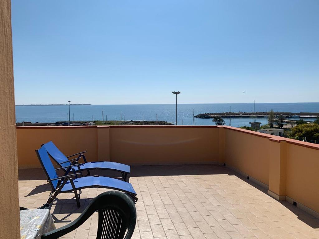 een blauwe bank op een balkon met uitzicht op de oceaan bij Mansarda pennisi in Le Castella