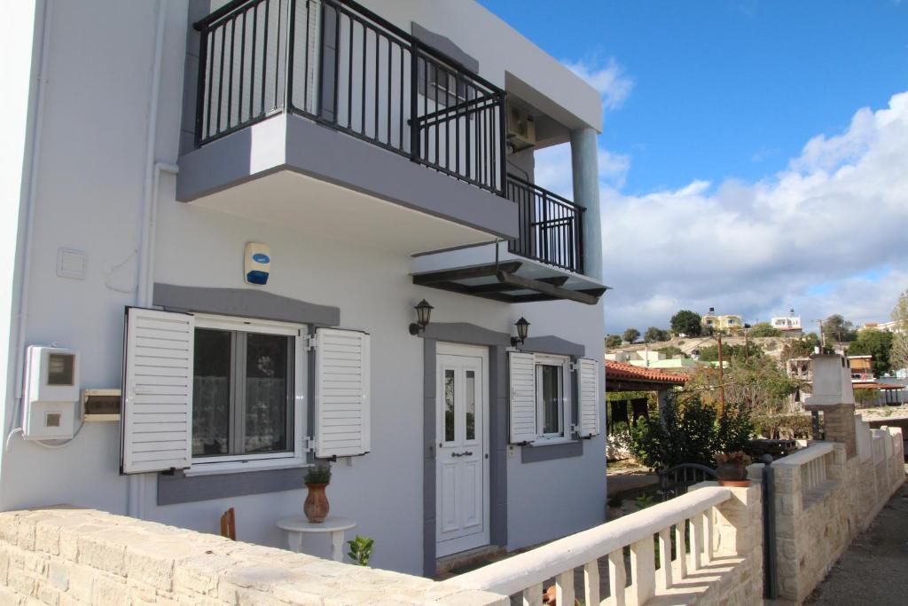 Casa blanca con balcón y escalera en Olympias Studio "Pitsidia" en Pitsidia