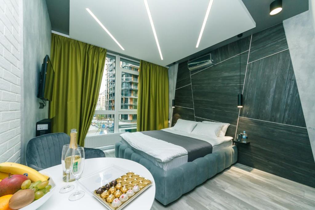una habitación de hotel con una cama y una mesa con un bol de fruta en Luxury Apartments, en Kiev