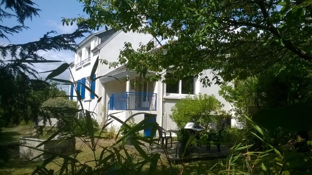 een wit huis met blauwe luiken erop bij MAISON KERLORZ in Bénodet