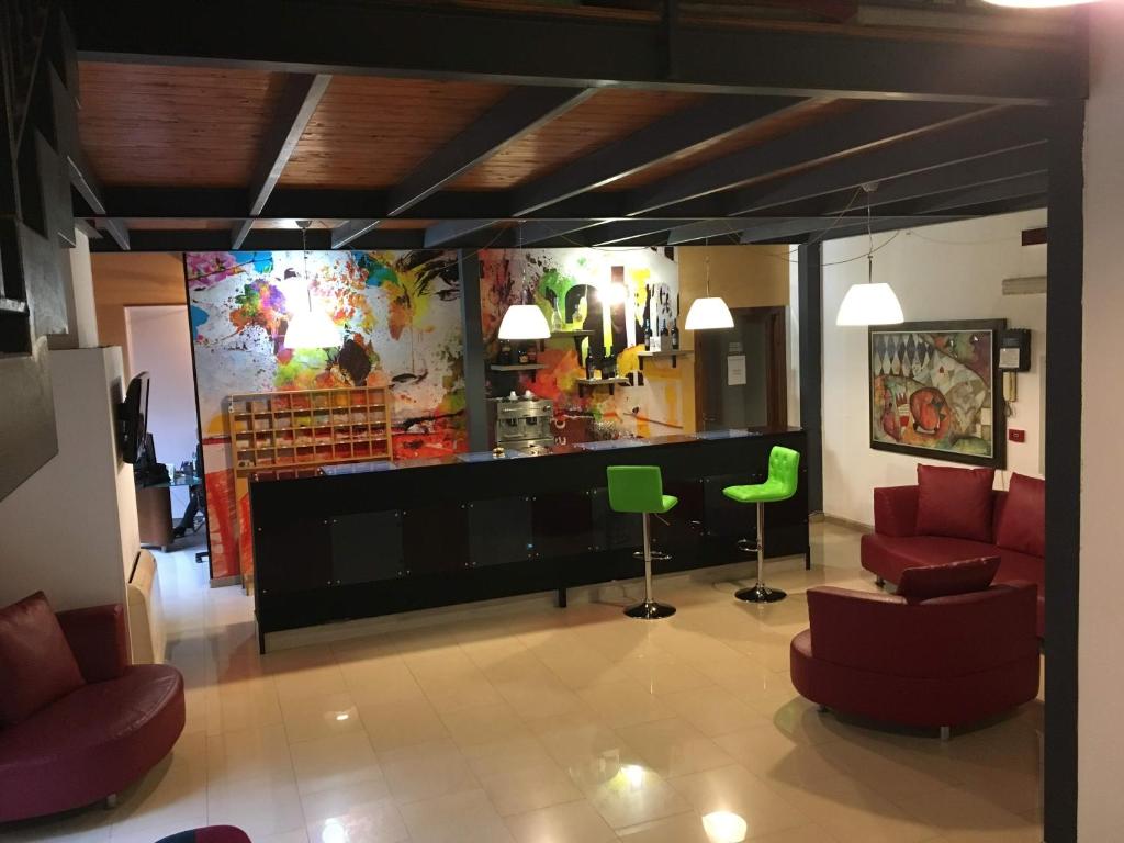 a lobby with red and green chairs and a store at Hotel Centrale in Syracuse