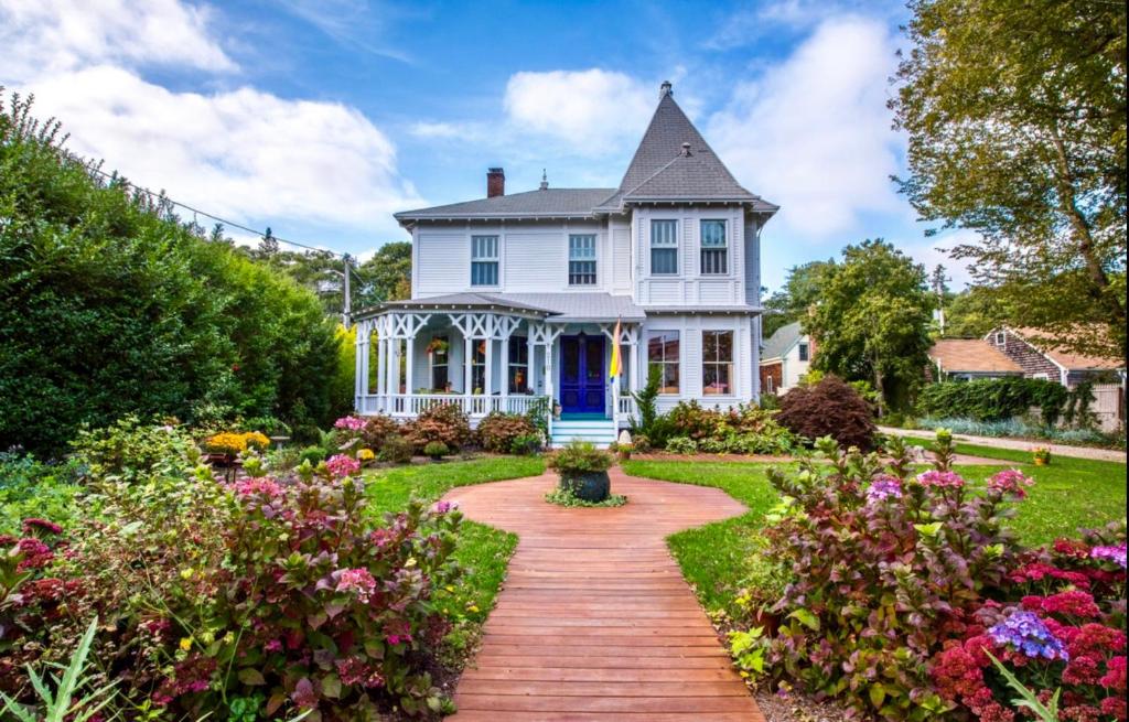 
a large white house with a large garden at Stowaway in Provincetown
