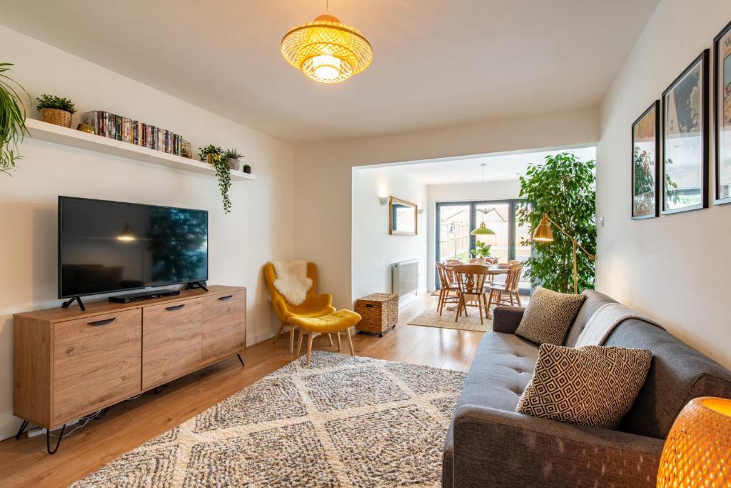 a living room with a couch and a flat screen tv at Beach Retreat in Whitstable