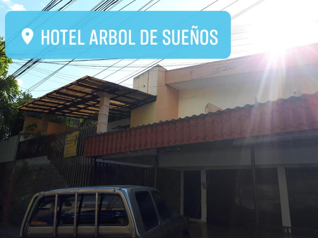 une voiture garée devant un bâtiment dans l'établissement Hotel Arbol de Sueños, à San Salvador