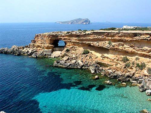 an island with a tunnel in the middle of the water at Can Mares in Cala Tarida