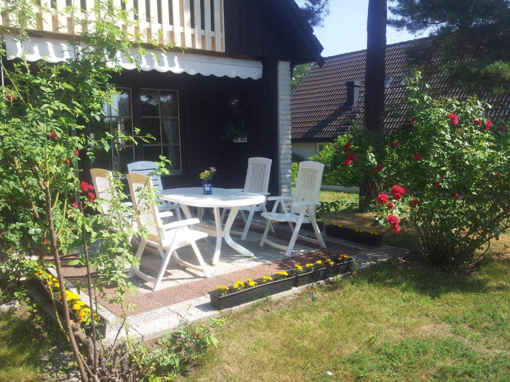 a patio with a table and chairs and flowers at Anitas B&B Stockholm/Vällingby in Stockholm