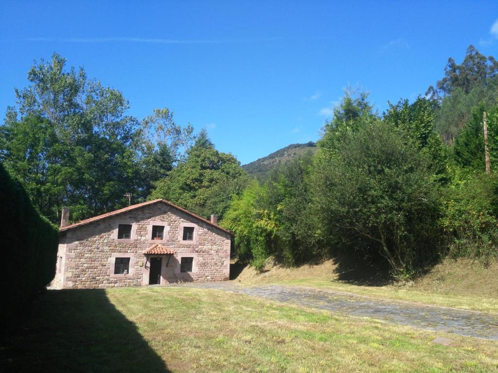 uma velha casa de pedra numa estrada num campo em Querencia em Carmona