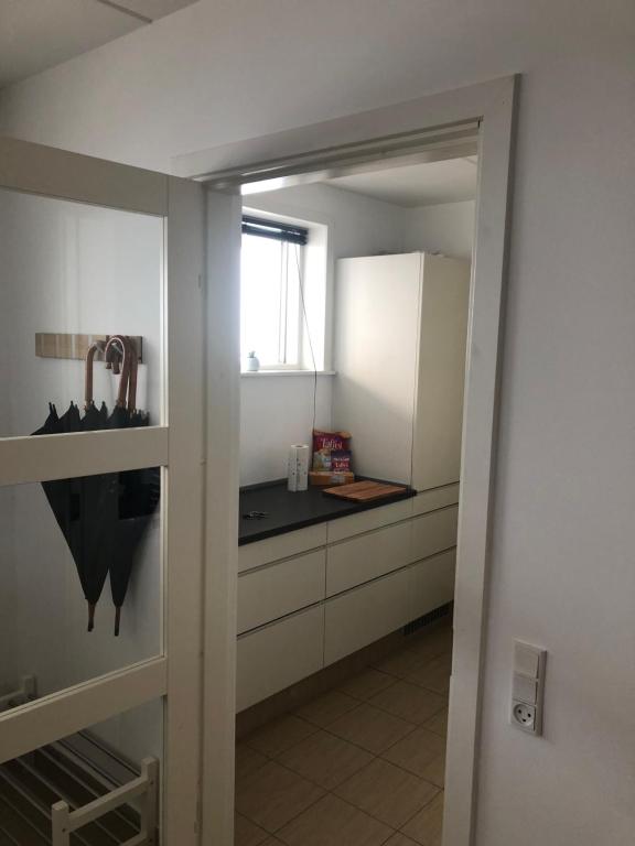 une cuisine avec des placards blancs et un comptoir noir dans l'établissement Cph Lux Apartment KV, à Copenhague