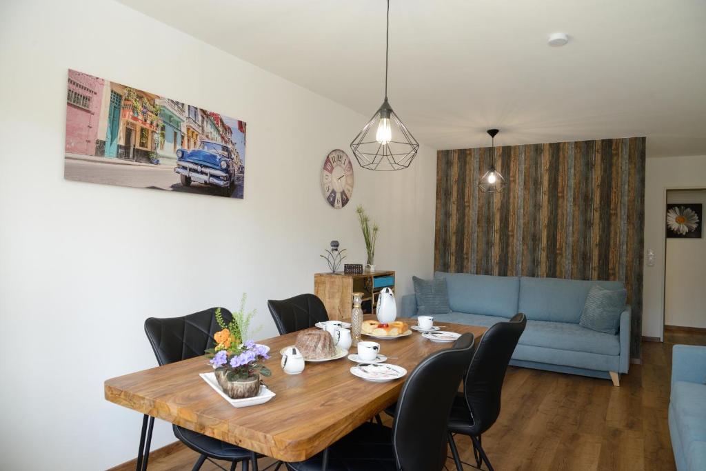 een woonkamer met een tafel en een blauwe bank bij Ferienwohnung Seenah in Gunzenhausen