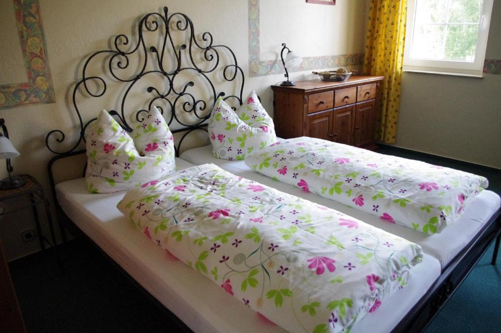 um quarto com 2 camas com lençóis brancos e flores cor-de-rosa em La Petite Provence em Leisnig
