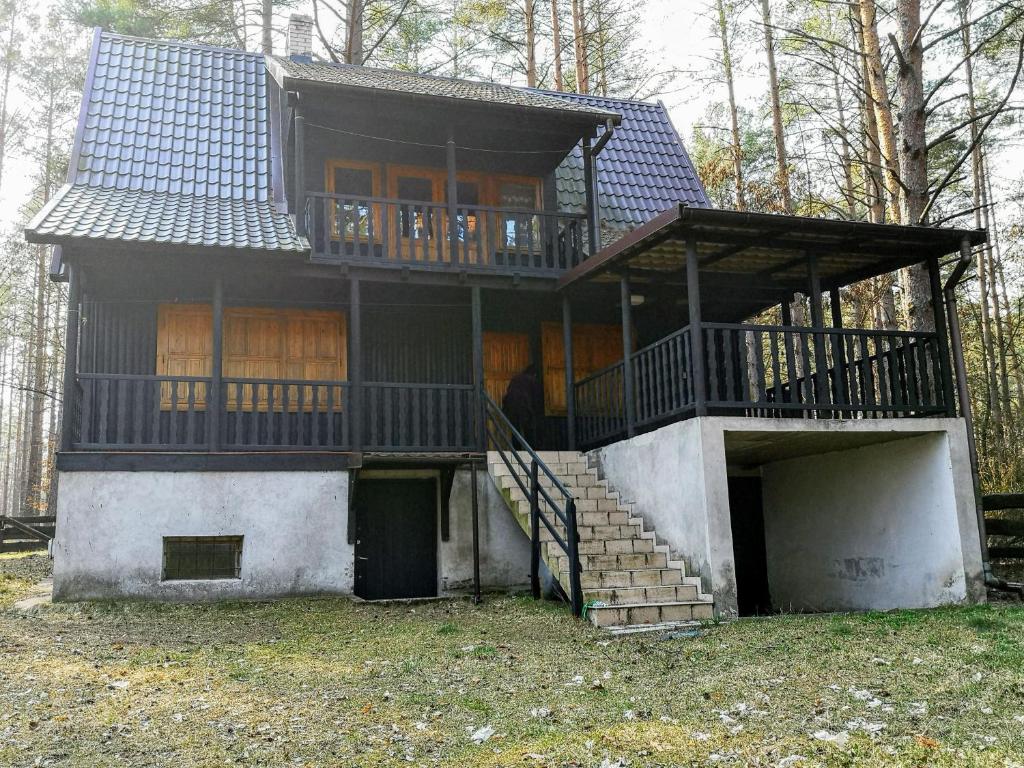 a large house with a balcony and stairs at Warchały near Szczytno, RUSTIC LODGE at Lake in Narty